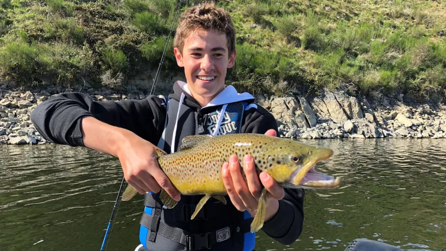 Angler holding a brown trout caught at Lake Opuha