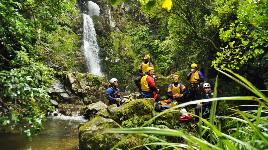Group of adventurers at waterfall in Kaumira Canyon