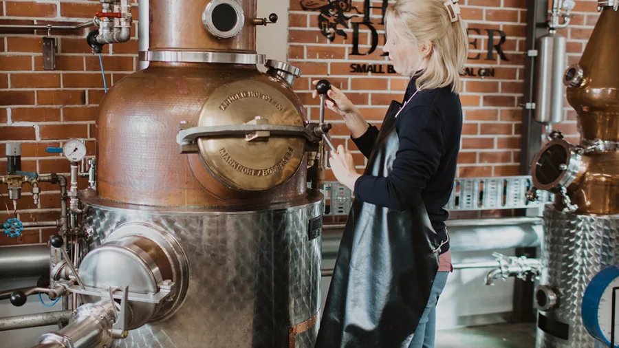 Woman operating copper still at Humdinger Gin Distillery, Geraldine
