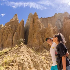 Couple walking among the towering Clay Cliffs in Ōmarama, New Zealand