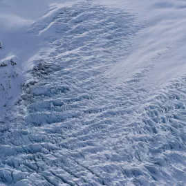 Aerial close-up of glacial crevasses and blue ice on a South Island glacier