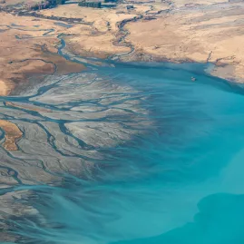Aerial image of braided rivers flowing into the turquoise waters of Lake Tekapo