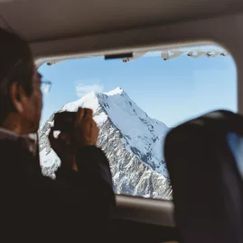 Passenger taking photo of Mt Cook from inside an Air Safaris scenic flight