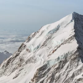 Close aerial shot of Mt Cook’s icefalls and crevassed ridgeline under blue skies