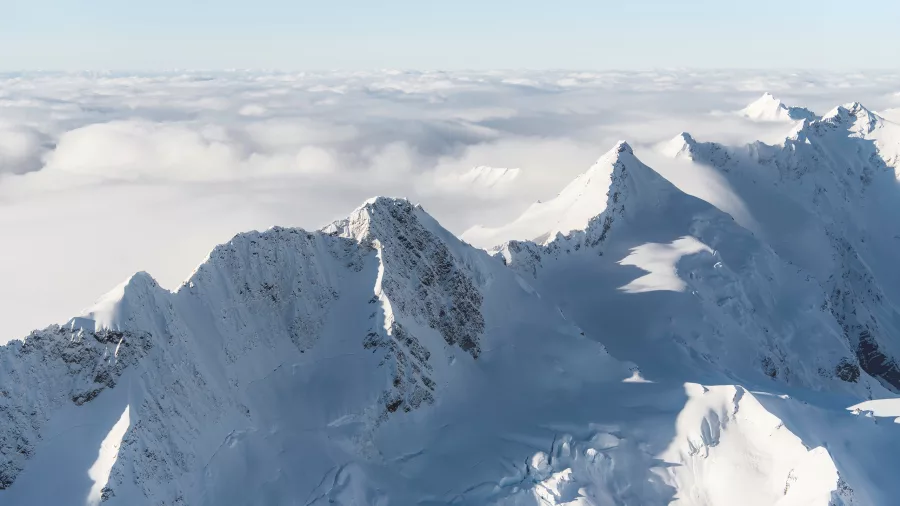 Southern Alps peaks rising above a thick cloud inversion on a sunny day