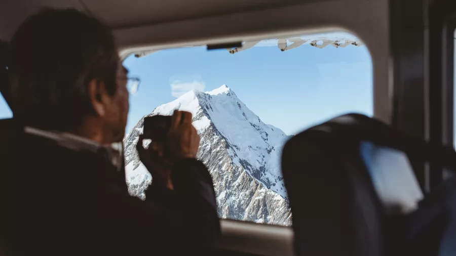 Passenger taking photo of Mt Cook from inside an Air Safaris scenic flight
