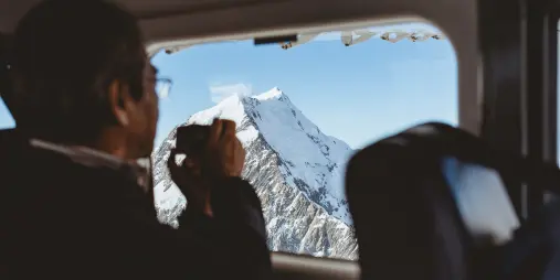 Passenger taking photo of Mt Cook from inside an Air Safaris scenic flight