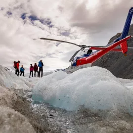 Group of hikers standing beside a helicopter on the Tasman Glacier at the start of their hike.