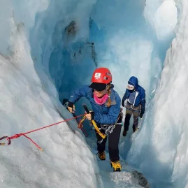 Climber making their way out of a deep ice crevasse on Tasman Glacier.