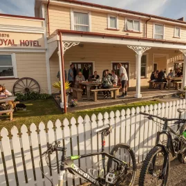 Bikes parked outside the Theatre Royal Hotel in Kumara with people dining outdoors