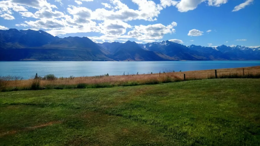 View of Lake Ohau with clear blue skies and rugged mountain ranges on the Alps 2 Ocean Cycle Trail