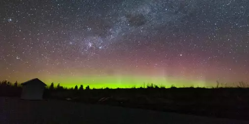 Aurora Australis glowing green and pink under the stars at Lake Tekapo