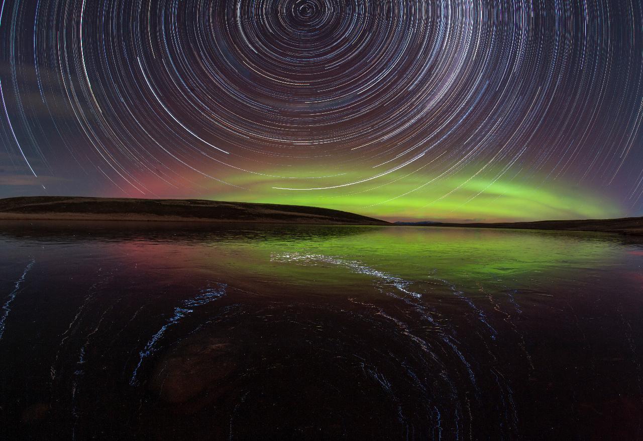 Aurora Australis and star trails reflected in a lake at Silver River's dark sky site