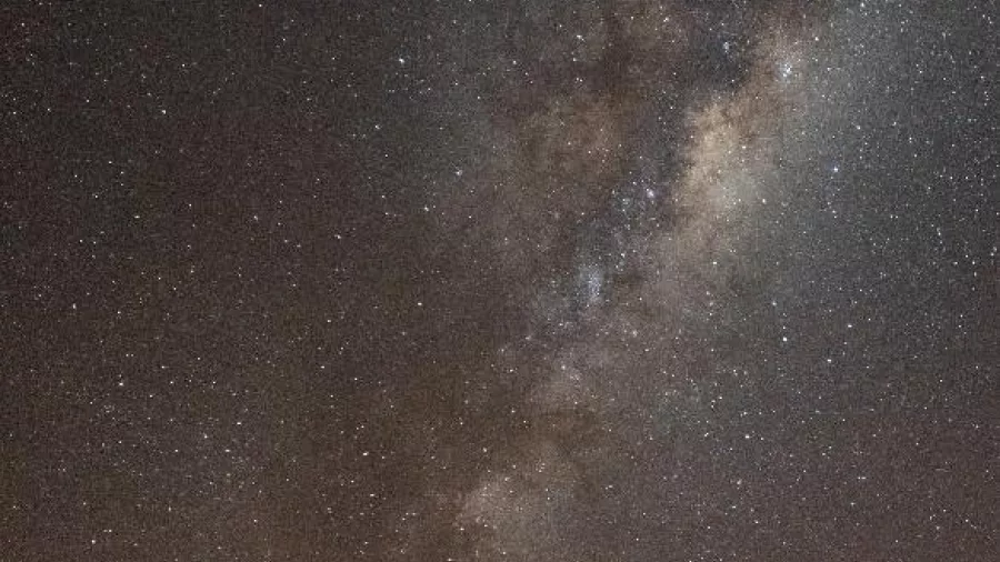 Group of stargazers pointing up at the Milky Way during a night tour in Twizel