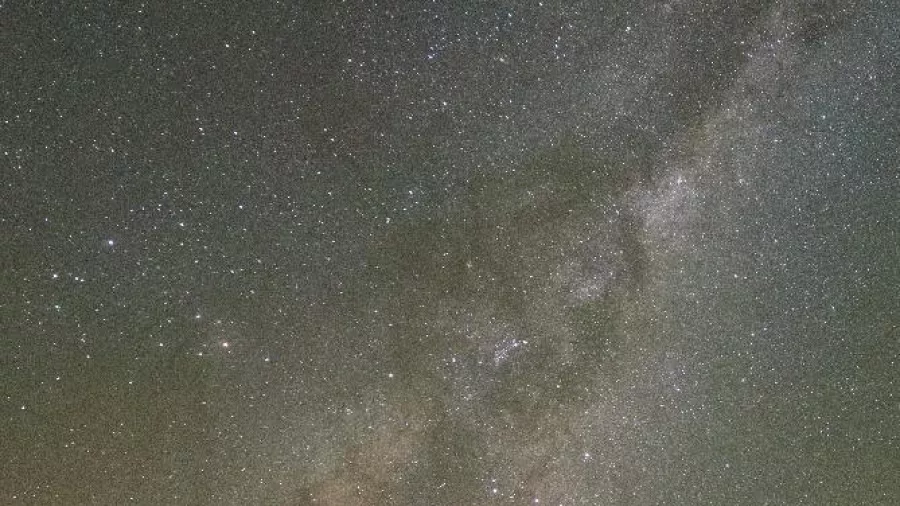 Solo guest standing beneath the Milky Way on a stargazing night in Twizel