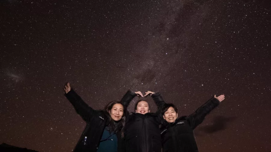 Group smiling under the Milky Way during a stargazing experience in Twizel