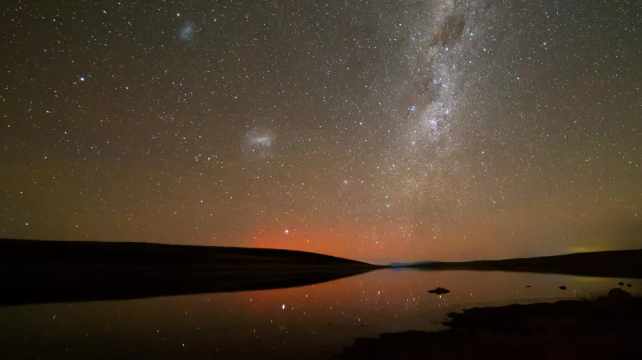 Still lake reflecting stars and galaxies under a dark sky at Lake Tekapo