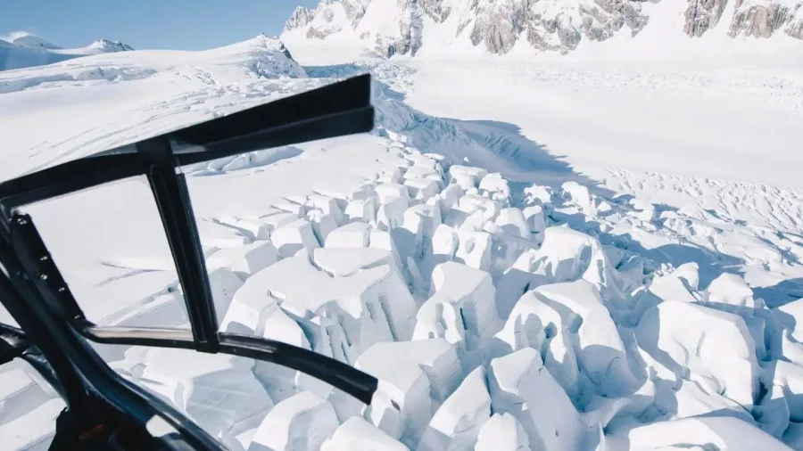 View from a helicopter flying over dramatic glacier crevasses in Aoraki/Mount Cook National Park