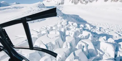 View from a helicopter flying over dramatic glacier crevasses in Aoraki/Mount Cook National Park