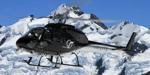 Helicopter flying over snowy peaks during the Grand Circle Scenic Flight at Mount Cook