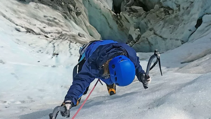 Climber scaling a steep ice wall on Tasman Glacier near Aoraki/Mount Cook.