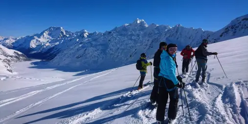 Group of skiers on Tasman Glacier with panoramic views of the Southern Alps near Mount Cook