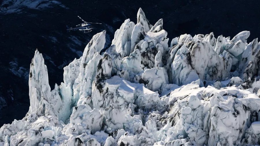 Helicopter flying over the rugged Hochstetter Glacier Icefall near Aoraki Mount Cook