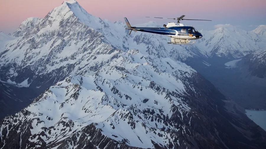 Helicopter flying past Aoraki/Mount Cook at sunset with glaciers and Lake Pukaki visible