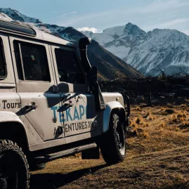 Tekapo Adventures 4WD parked with dramatic snow-covered peaks in the background