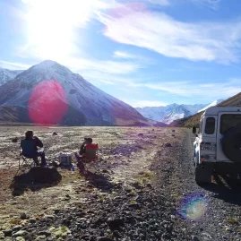 Travellers enjoying an afternoon tea break in a remote alpine valley on a 4WD tour