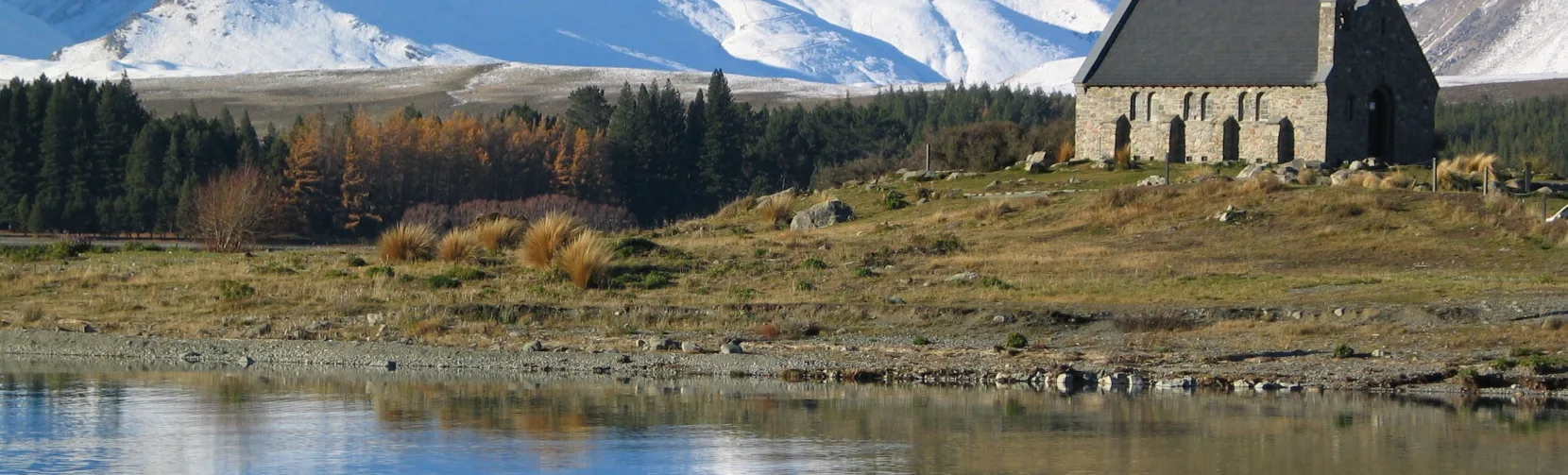 Church of the Good Shepherd with snowy mountains reflecting in Lake Tekapo