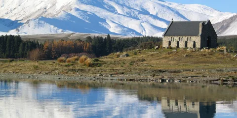 Church of the Good Shepherd with snowy mountains reflecting in Lake Tekapo