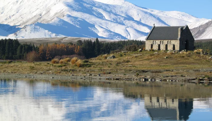 Church of the Good Shepherd with snowy mountains reflecting in Lake Tekapo