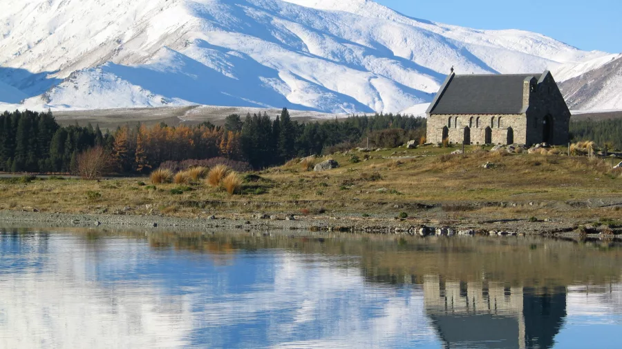 Church of the Good Shepherd with snowy mountains reflecting in Lake Tekapo