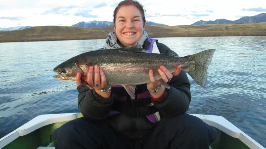 Woman holding freshly caught rainbow trout at Lake Alexandrina in Mackenzie Region