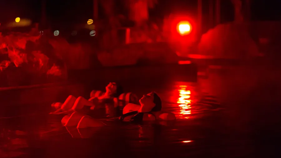 Mother and daughter stargazing in Tekapo Springs hot pools at night