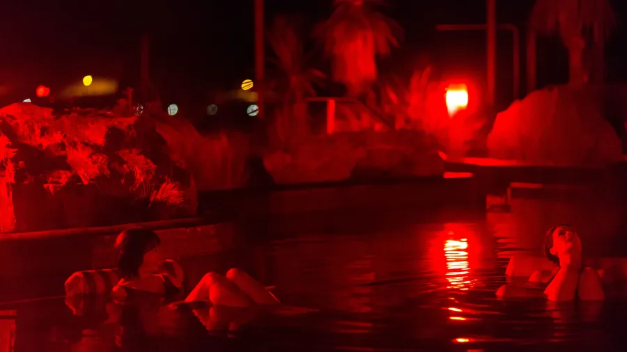Night hot pool stargazing experience at Tekapo Springs with red light setting