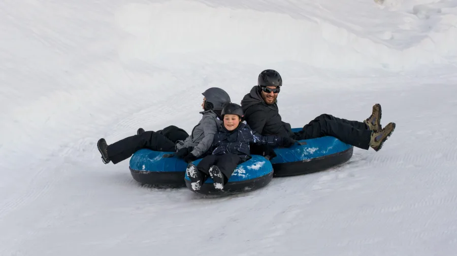 Family enjoying snow tubing at Tekapo Springs, Lake Tekapo