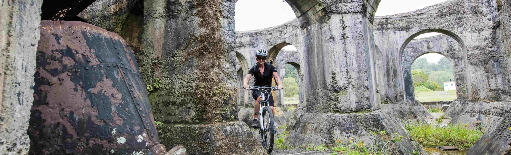 Cyclist at Victoria Battery ruins in Karangahake Gorge