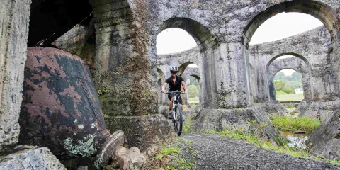 Cyclist at Victoria Battery ruins in Karangahake Gorge