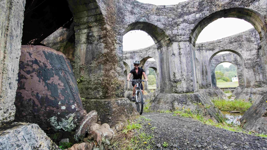 Cyclist at Victoria Battery ruins in Karangahake Gorge
