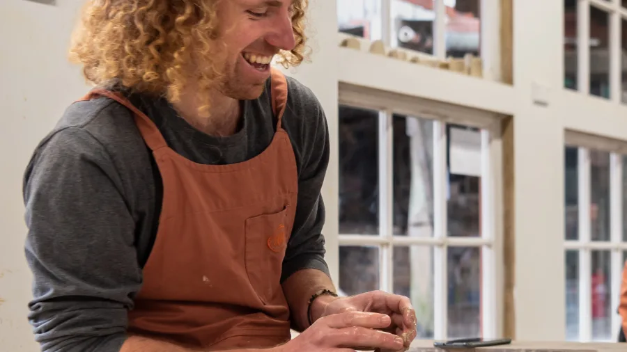 Pottery class tutor demonstrating wheel throwing at Driving Creek