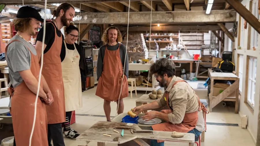Instructor demonstrating pottery to a small group during a Driving Creek class