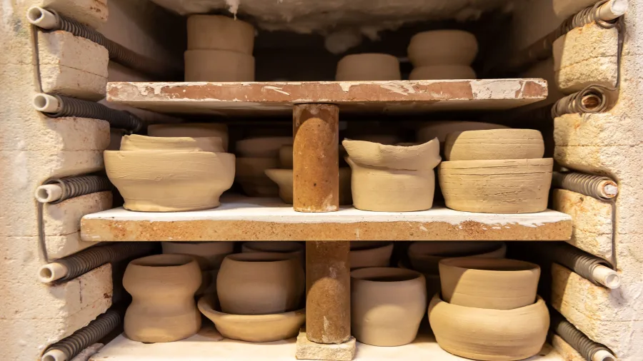 Unfired clay bowls stacked inside a pottery kiln at Driving Creek