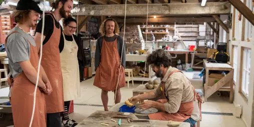 Instructor demonstrating pottery to a small group during a Driving Creek class
