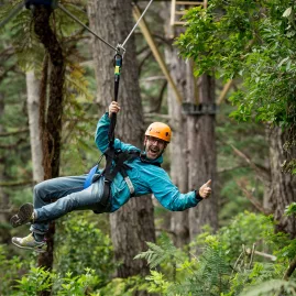 Man giving a thumbs up while ziplining through Coromandel’s native bush