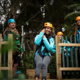 Young woman smiling before launching from the zipline platform in Coromandel
