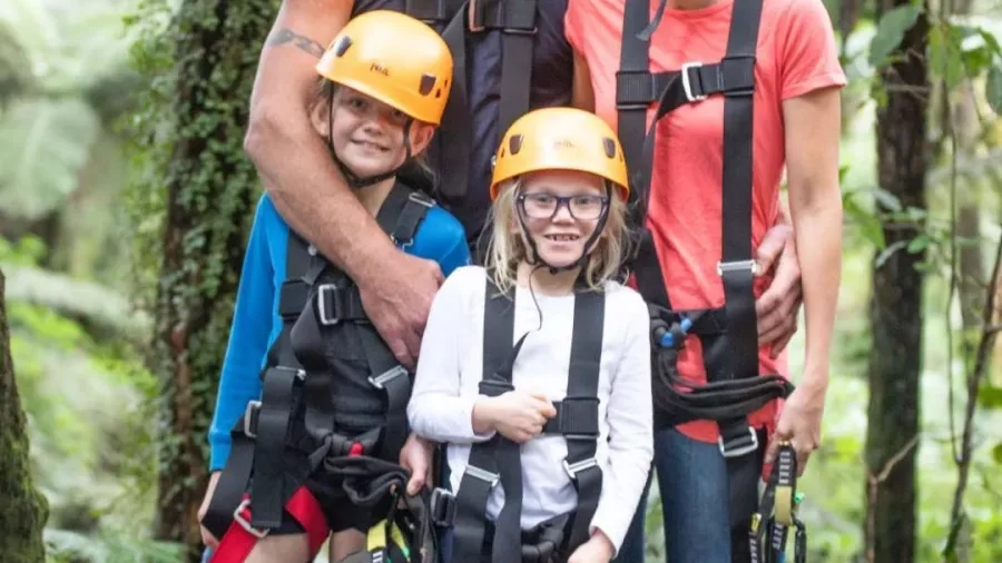 Smiling family in harnesses ready for Coromandel Zipline Tour at Driving Creek