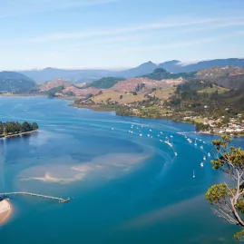 Aerial view of the Paradise Coast with Tairua Estuary, sandy beaches, boats, and rolling hills on the Coromandel Peninsula, New Zealand