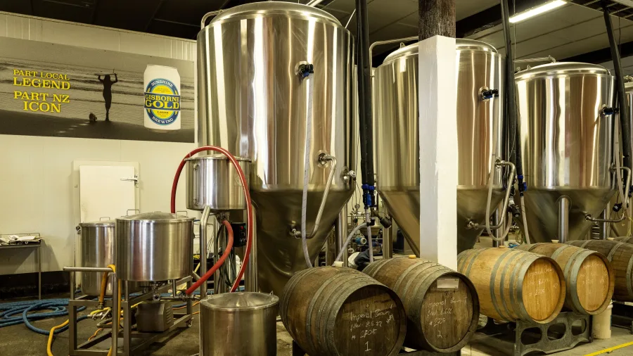 Shiny fermentation tanks and barrels at Sunshine Brewery in Gisborne